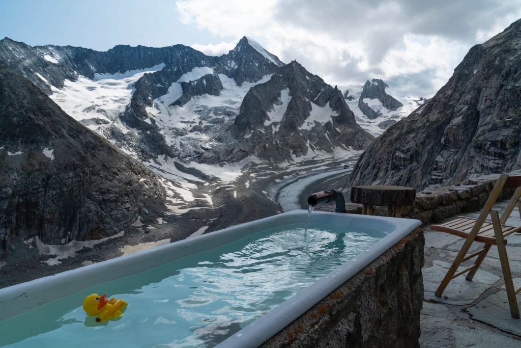 Un baño de hielo al aire libre rodeado de un paisaje montañoso nevado, que ofrece una experiencia serena y vigorizante.