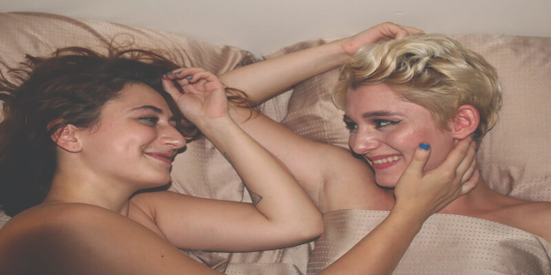 Imagen de una pareja en la cama sonriendo